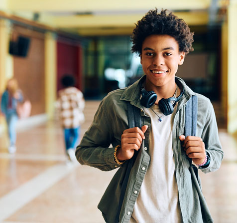 Young male student walking in school hallway